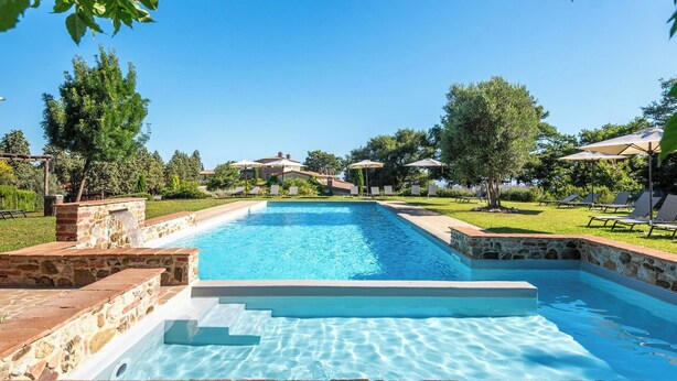 A rectangular swimming pool with stone steps leading into it, surrounded by a grassy area with trees and umbrellas. - Apartment with A/C, pool, WIFI, TV, patio, pets allowed, panoramic view, close to Montepulciano (Torrita Di Siena)
