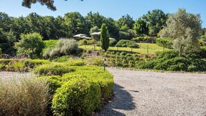 A landscaped garden with pathways, neatly trimmed hedges, and a variety of trees and shrubs. - Apartment with A/C, pool, WIFI, TV, patio, pets allowed, panoramic view, close to Montepulciano (Torrita Di Siena)