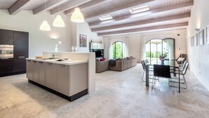A spacious kitchen with a central island, a dining area with a table and chairs, and a living area with a sofa and a large window. - Apartment with A/C, pool, WIFI, TV, patio, pets allowed, panoramic view, close to Montepulciano (Torrita Di Siena)