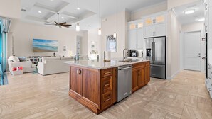 Una cocina moderna con una isla central, electrodomésticos de acero inoxidable y muebles de madera.