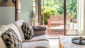 Una sala de estar acogedora con un sofá, cojines y una mesa con un adorno.