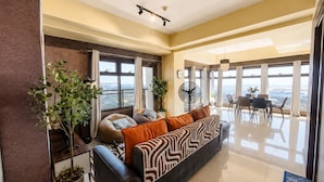 Ein modernes Wohnzimmer mit Sofa, Essbereich und Blick auf die Stadt.