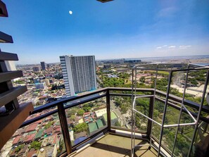 Un edificio de gran altura con vistas a un paisaje urbano, incluyendo una noria.