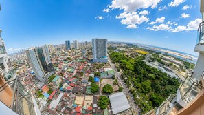 Une vue panoramique d’une ville, avec ses gratte-ciel, son centre urbain dense et une rivière.