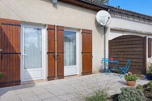 A house with a patio, a satellite dish, and a wooden gate.