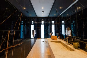 A modern interior with a central marble staircase, a reception desk, and a view of the outside through large windows. - Spacious 5-bedroom villa in peaceful Marrakech-Safi with AC (Marrakech-Safi)