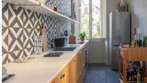 Een moderne keuken met een backsplash met geometrisch patroon, houten keukenkastjes en een ingebouwde oven.