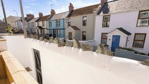 Una hilera de casas adosadas con un muro blanco al frente.