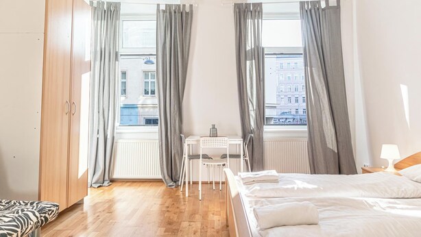 Une chambre à coucher comprenant un lit, un bureau, une chaise et une armoire.