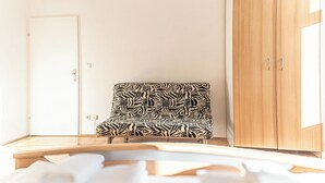 Une pièce avec une chaise à motifs zébrés, une armoire en bois et une porte blanche.