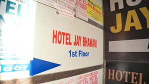 A wall with multiple signs for HOTEL JAY BHAWANI, including a prominent sign for the 1st floor. - HOTEL JAY BHAWANI (Ahmedabad)