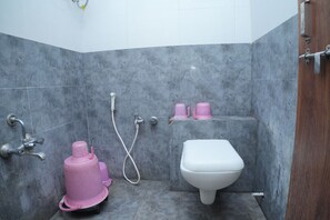 Un baño con ducha, inodoro y detalles en rosa.