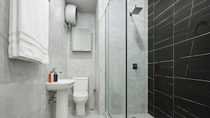 A modern bathroom with a glass-enclosed shower, a white sink, and a toilet. - Monica Apartment (Abuja)