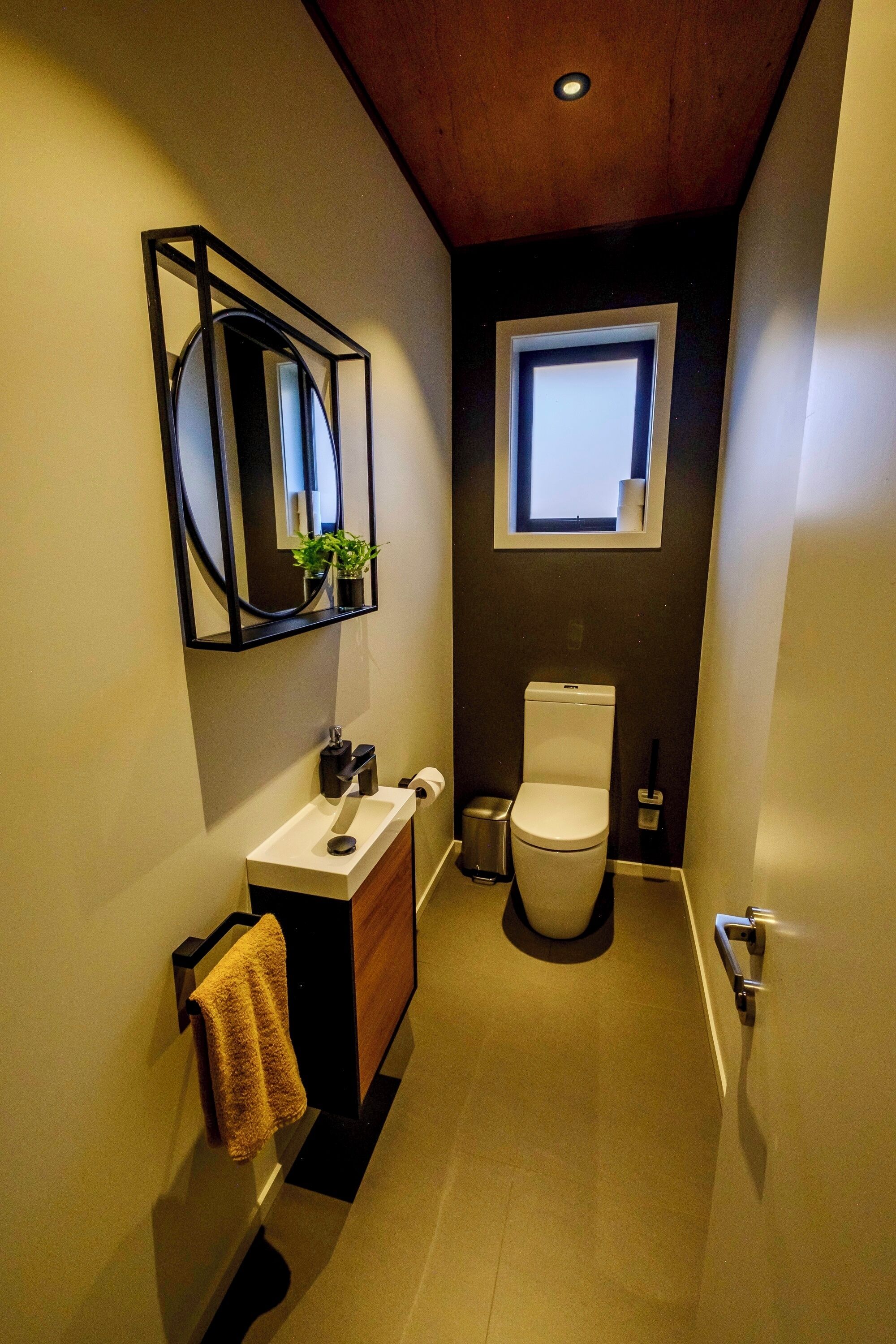 Un baño pequeño con inodoro, lavamanos y espejo.