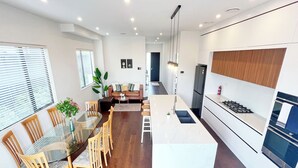 Une cuisine moderne avec un îlot central, une table à manger en bois et des chaises.