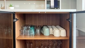 Une cuisine moderne avec des meubles en bois, un meuble-bar intégré et un plan de travail agrémenté d’une plante en pot.