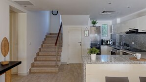 A modern kitchen with granite countertops, stainless steel appliances, and a built-in oven. - Vesta - Luxury Villa - 4BR - Joubal (El Gouna)