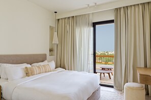 Une chambre d’hôtel avec un lit, une petite table et un balcon avec des rideaux.