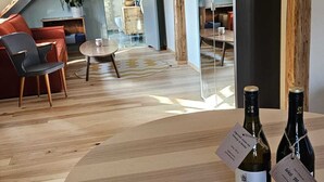 A cozy loft-style living room with a wooden floor, a round table with two wine bottles, and a red sofa. - Turkusowa Wyspa (Wlen)