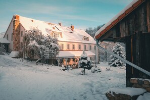 A large house with a snow-covered roof and a stone chimney. - Turkusowa Wyspa (Wlen)