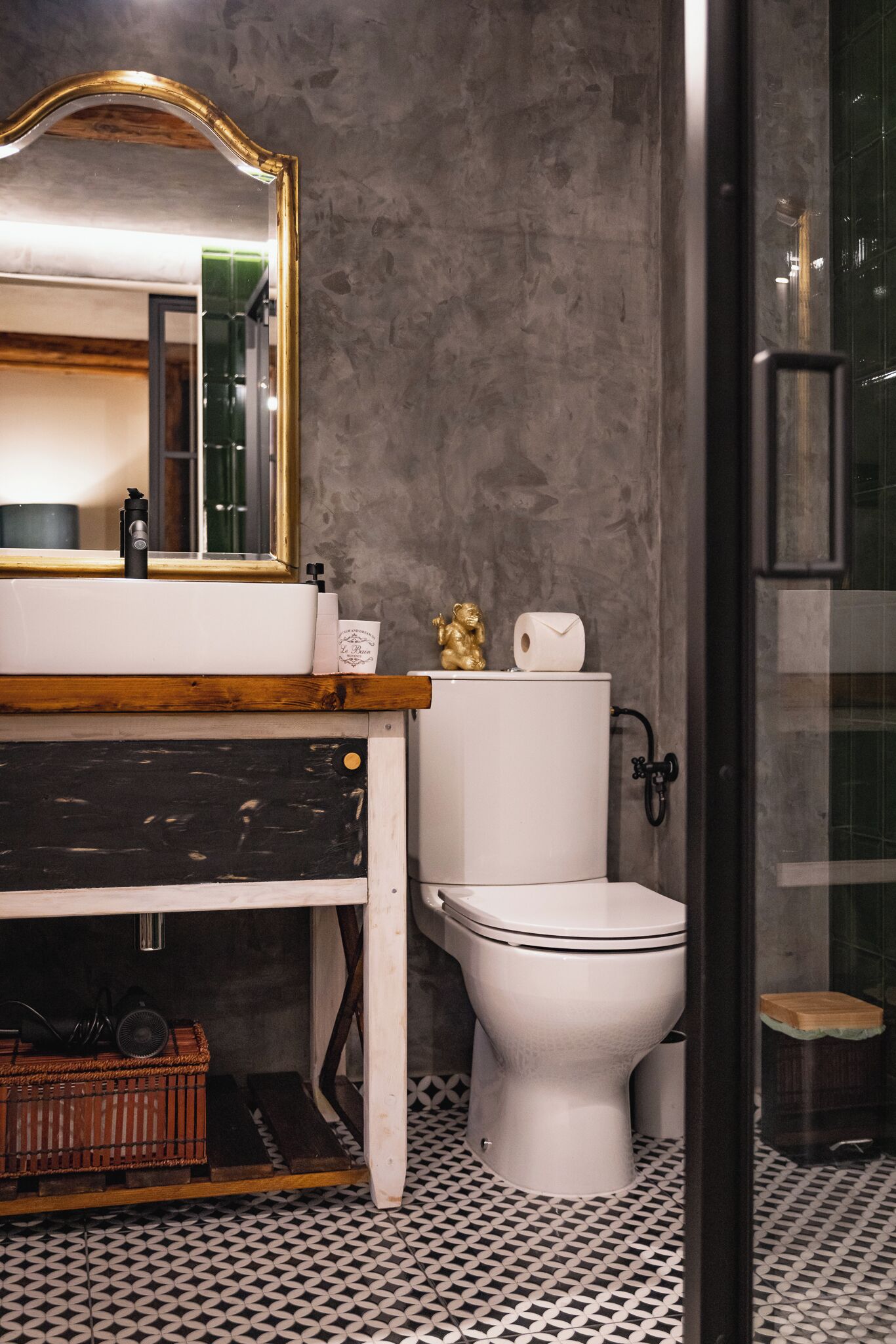 A bathroom with a white sink, a toilet, and a mirror.