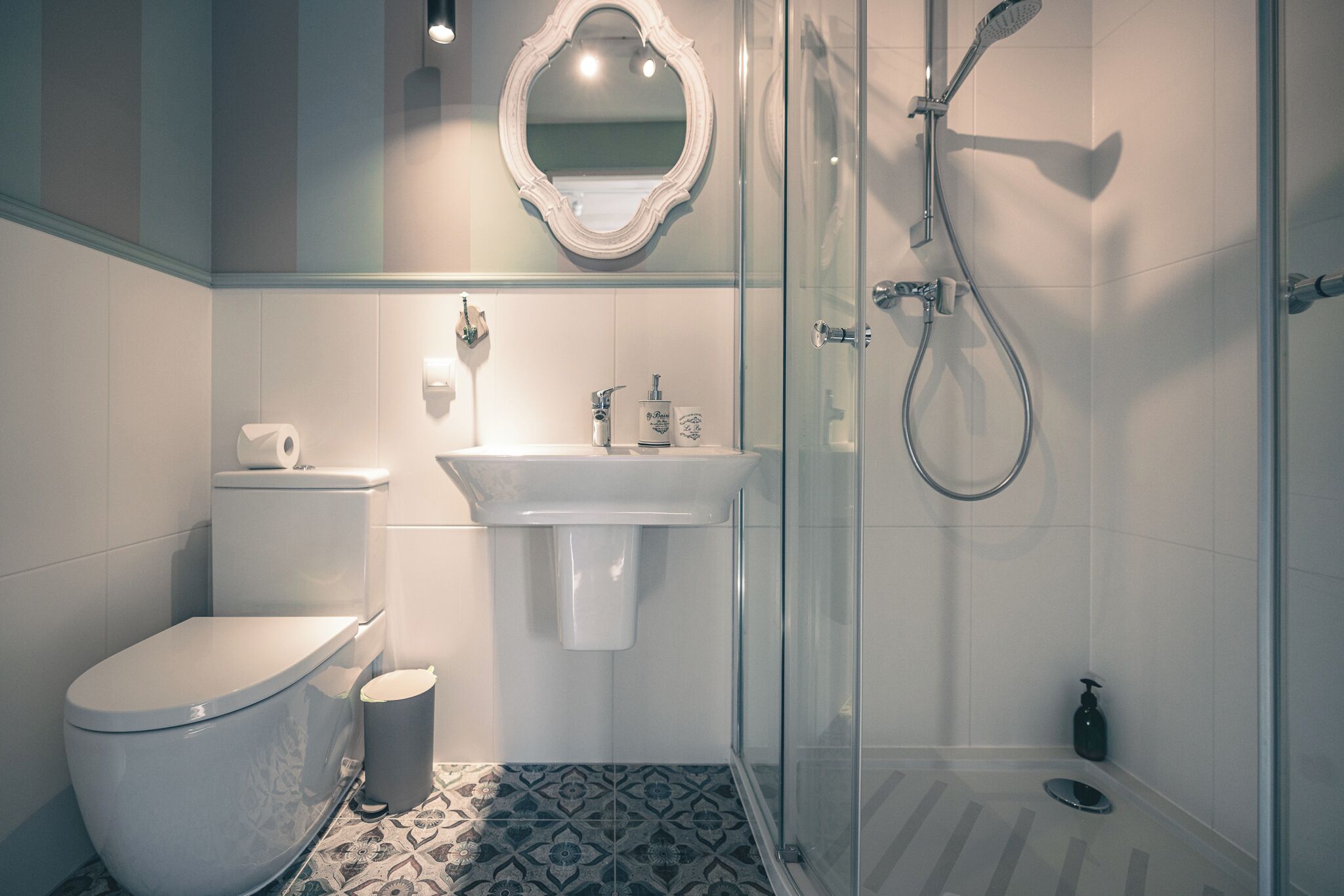 A modern bathroom with a toilet, sink, and glass-enclosed shower.