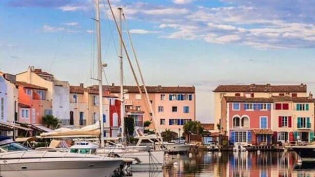 Un port de plaisance avec des bâtiments aux couleurs vives et des bateaux amarrés.