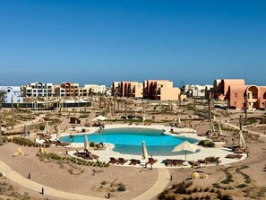 A resort with a central pool, multiple buildings, and a desert landscape. - Vesta - Luxury APT - 2BR - Kamaran (El Gouna)