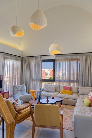 Uma sala de estar moderna com um sofá, uma mesa de centro e um espaço de jantar.