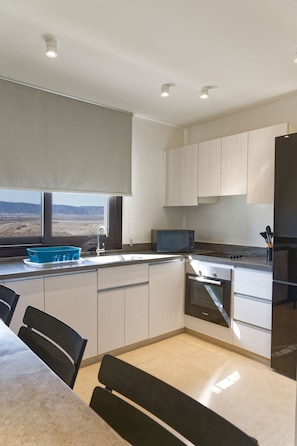 A modern kitchen with a window view, built-in microwave, and stainless steel appliances. - Vesta - Luxury APT - 2BR - Kamaran (El Gouna)