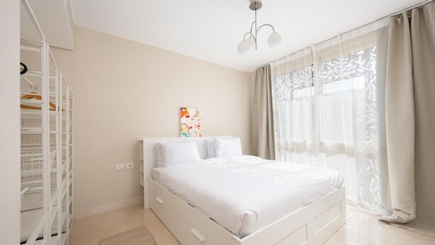 A bedroom with a white bed, a wardrobe, and a window with sheer curtains. - Vesta - Luxury APT - 2BR - Mangrovy (El Gouna)
