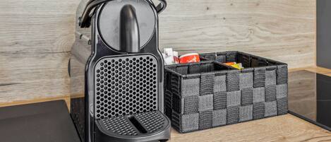 A coffee machine and a storage basket on a wooden surface.