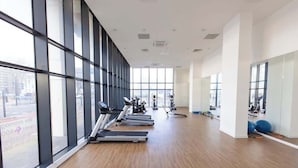 A spacious gym with treadmills, stationary bikes, and exercise balls, large windows, and a wooden floor. - Quayside Penthouse w/ City Views & Fast WiFi (Greater Manchester)