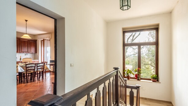 A staircase with wooden railings leading to a room with a window overlooking a garden. - Apartment 'Casa Vacanza Montecapino' in the Tuscan Hills (Chiusdino)