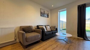 A living room with a sofa, armchair, and a small table. - Family-Friendly House Near Manchester, Pet (Greater Manchester)