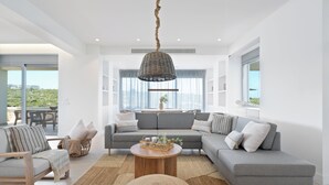 A modern living room with a grey sectional sofa, a wooden coffee table, and a woven rug. - Le Mont Blanc (Kounoupidiana)