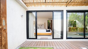 A modern bedroom with a large sliding glass door leading to a balcony. - Solla Sol Villa Canggu (Kerobokan)