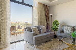 A modern living room with two grey sofas, a glass coffee table, and a potted plant. - Vesta - Luxury Apt- 3BR - Cfc Xli (New Cairo)