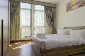 A bedroom with a wooden bed, white bedding, and a view through a window with sheer curtains. - Vesta - Luxury Apt- 3BR - Cfc Xli (New Cairo)