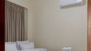 A bedroom with a bed, curtains, an air conditioning unit, and a ceiling light. - Vesta - Luxury APT - 2BR - La Mirada II (New Cairo)