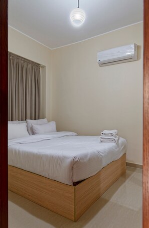 A bedroom with a bed, curtains, an air conditioning unit, and a ceiling light. - Vesta - Luxury APT - 2BR - La Mirada II (New Cairo)