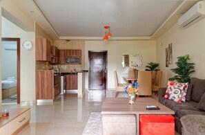 Uma sala de estar moderna com sofá, mesa de centro e área de jantar.