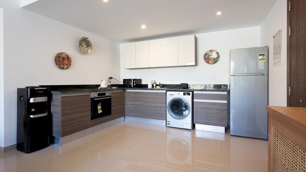 A modern kitchen with a built-in washing machine, a refrigerator, and a water dispenser. - Vesta - Luxury APT - 2BR - Gcribs III (El Gouna)