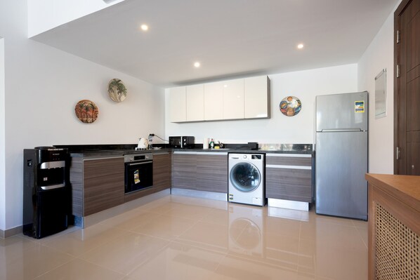 A modern kitchen with a built-in washing machine, a refrigerator, and a water dispenser. - Vesta - Luxury APT - 2BR - Gcribs III (El Gouna)