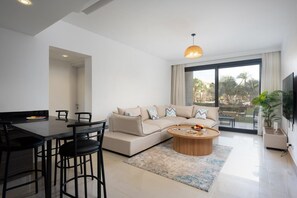 A modern living room with a sofa, coffee table, and dining area. - Vesta - Luxury APT - 2BR - G-cribs IV (El Gouna)