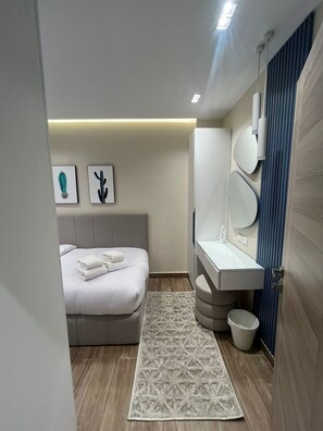 Ein modernes Schlafzimmer mit Bett, Nachttisch und einem großen Spiegel.