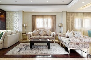Un salon avec deux canapés, une table basse et un tapis à motifs.