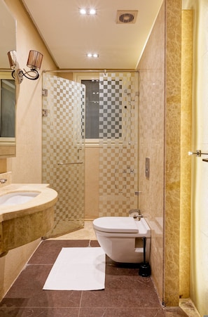 Ein Badezimmer mit Duschkabine mit Schachbrettmuster, Toilette und Waschbecken.