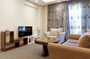 A modern living room with a flat-screen TV, a marble coffee table, a sofa, and a patterned armchair. - Vesta - Luxury Studio - New Cairo I (New Cairo)
