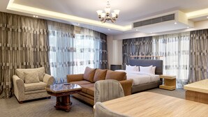 A modern hotel room with a large bed, a sofa, a dining table, and a chandelier. - Vesta - Luxury Studio - New Cairo I (New Cairo)
